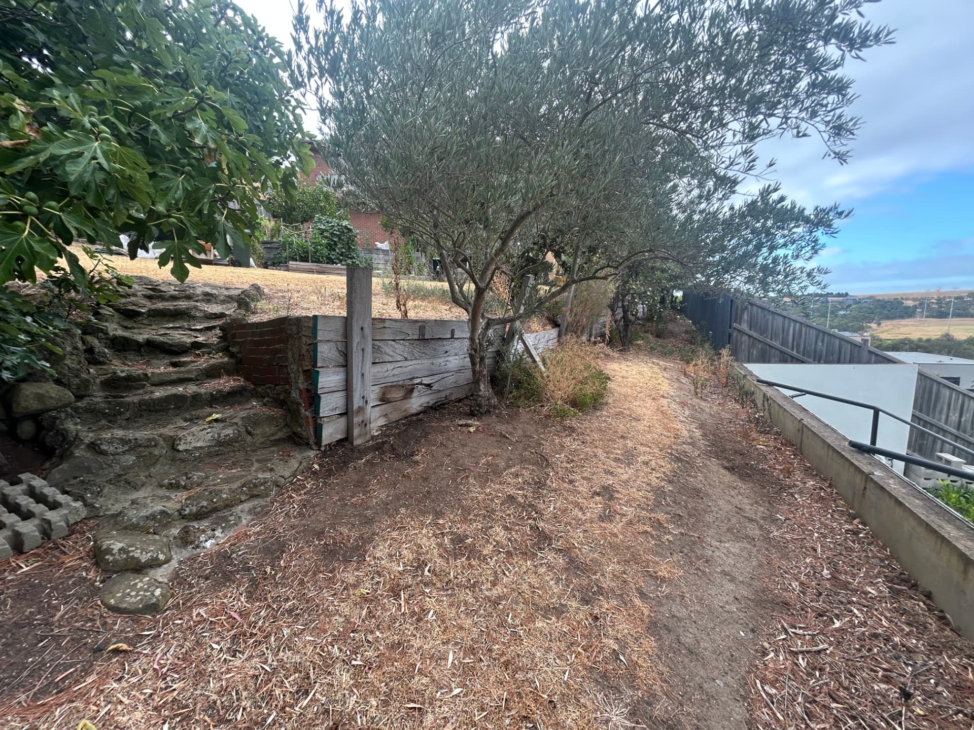 Failing timber sleeper wall on the upper path before works