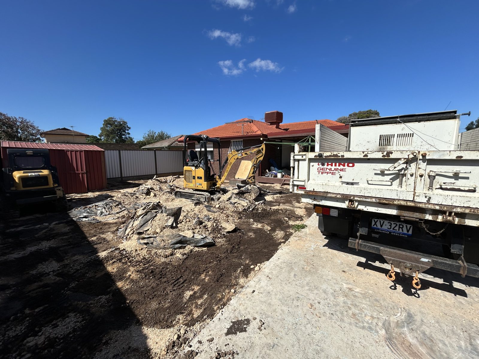 Rigid Earthworks excavator, Posi-Track and Hino tipper working together on a residential clean-up