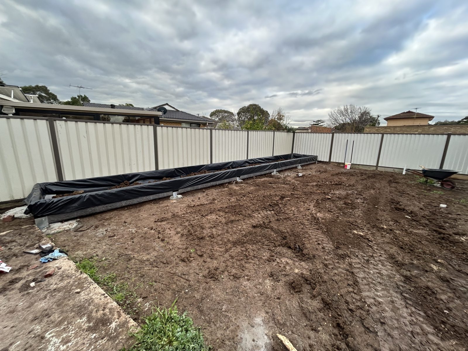 Two completed concrete sleeper walls with the yard graded level